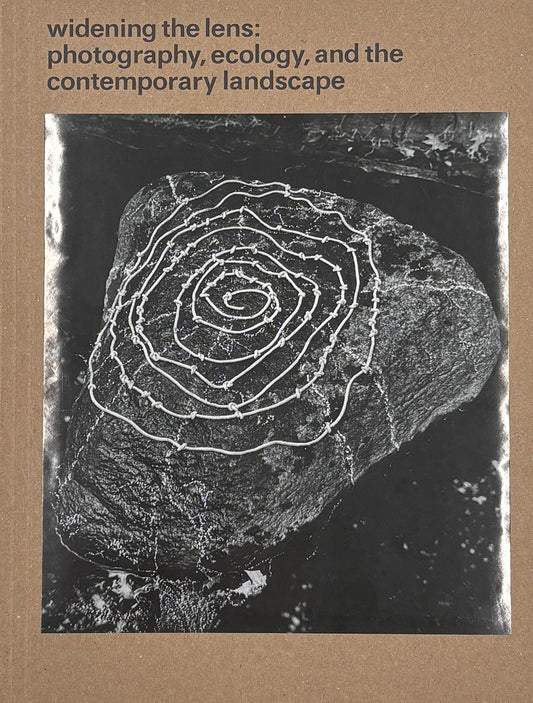 Book cover with a black and white spiral design on a rock, set against a brown background with text about photography and ecology.