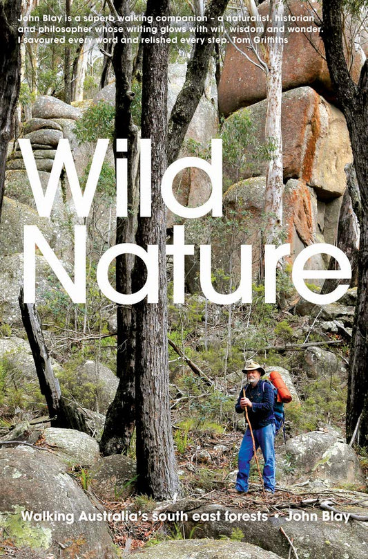 The cover of the book 'Wild Nature: Walking Australia’s South East Forests' by John Blay features a man with a hat and backpack, standing in a forested area with large rocks and trees in the background.