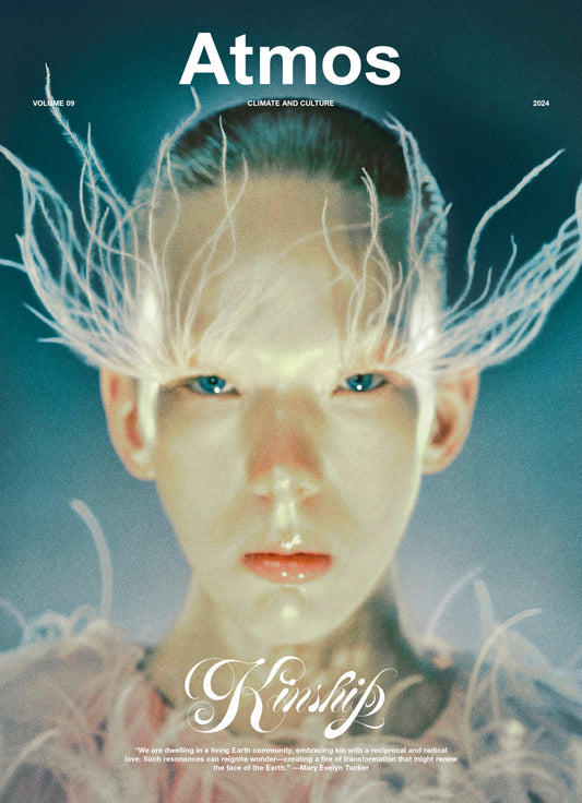 Magazine cover with a person with white hair and blue eyes, featuring the brand 'Atmos'.