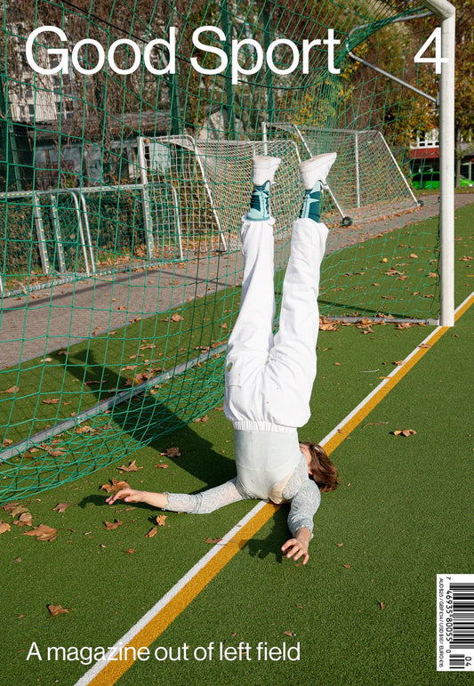 A cover of 'Good Sport Magazine Vol 4' featuring a person on their back in a soccer goal, with the goal and soccer field in the background.