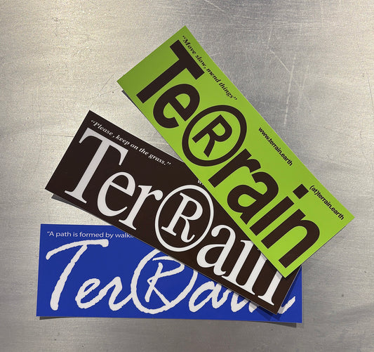 Three 'Terrain' branded stickers on a metallic surface